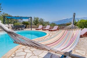 a hammock next to a swimming pool at Villa Jimmy's Katomeri 3 in Meganisi