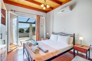 a bedroom with a bed and a balcony at Villa Jimmy's Katomeri 3 in Meganisi +19 photos