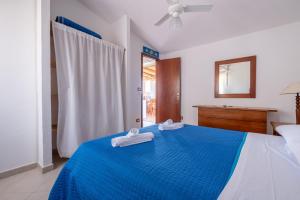 a bedroom with a blue bed with towels on it at Jerà D72 Vista Mare in Vulcano