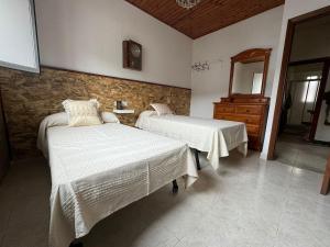 a bedroom with two beds and a dresser at O Lar Tuna in Pereiro