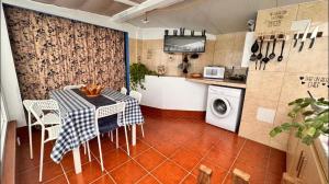 a kitchen with a table and a washing machine at O Lar Tuna in Pereiro