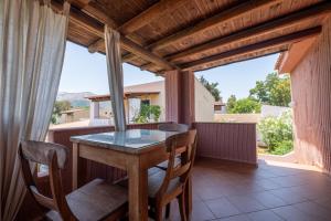 a dining room with a table and chairs on a balcony at Jerà D72 Vista Mare in Vulcano