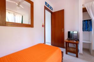 a bedroom with an orange bed and a mirror at Jerà D72 Vista Mare in Vulcano
