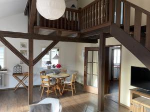 a dining room and living room with a loft at Ferienhaus Lena in Seebach