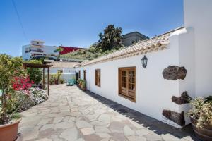 a courtyard of a white house with potted plants at Volcán 16 in Tanque