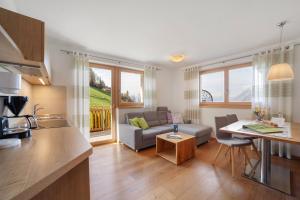 a kitchen and living room with a couch and a table at Ederhof in Schenna