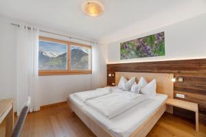a bedroom with a large bed and a window at Ederhof in Schenna