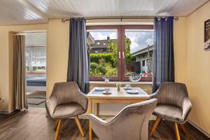 a dining room with a table and chairs and a window at Ferienwohnung Carstens in Itzehoe