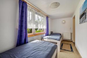 a bedroom with two beds and a window at Ferienwohnung Carstens in Itzehoe