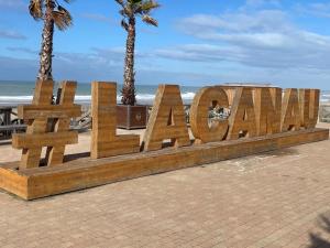 a wooden sign that reads navaho on the beach at La Cabane des P’tits chiffon in Lacanau +3 photos