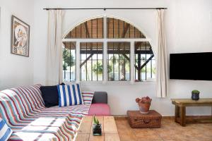 a living room with a couch and a tv at Casa Luna in Los Caños de Meca
