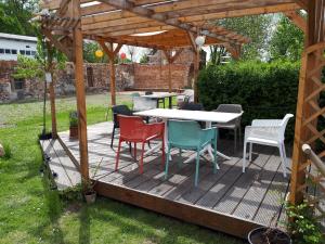 a wooden deck with a table and chairs under a pergola at ehemaliges Gutsverwalterhaus in Mildenitz