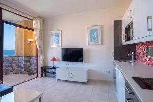 a kitchen with a tv on the wall at Stunning Marina view apartment in Fuengirola