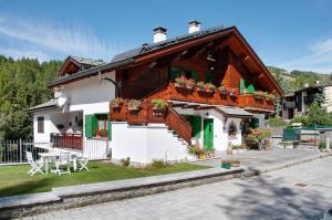 a house with a balcony and a table at Ginepro Casa Vacanze in Madesimo