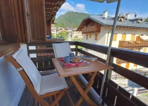 a table and a chair on a balcony with a view at Antelao Relax a Vinigo in Vinigo