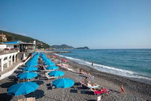 a beach with blue umbrellas and people on the beach at Casa Lulu' in Lavagna
