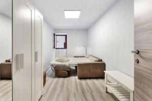 a bedroom with a bed and a couch in a room at Casa Vacanza Malva in Baveno