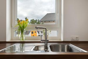 a kitchen sink with a window and a vase of flowers at Fewo Am Otterbach in Jockgrim +22 photos