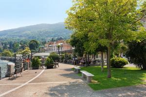 a park with benches and tables and a tree at Casa Vacanza Malva in Baveno