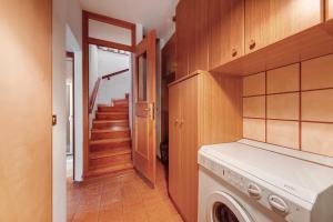 a laundry room with a washer and a staircase at Villa Maria Auronzo in Auronzo di Cadore
