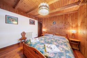 a bedroom with a bed in a room with wooden walls at Villa Maria Auronzo in Auronzo di Cadore