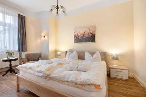 a bedroom with a large bed with white sheets and pillows at Haus Margarete Christel Winkelmann in Cuxhaven
