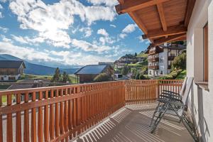 a chair on a balcony with a view of the mountains at Villa Solinda App Vivaldi in Selva