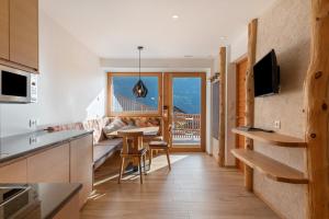 a kitchen and living room with a view of a balcony at Villa Solinda App Vivaldi in Selva