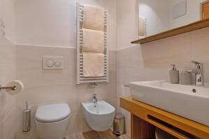 a bathroom with a white toilet and a sink at Villa Solinda App Vivaldi in Selva +25 photos
