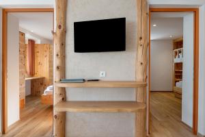 a room with a book shelf and a tv on a wall at Villa Solinda App Vivaldi in Selva
