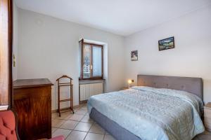 a bedroom with a bed and a desk and a window at Casa Daniela in Druogno