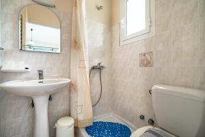 a bathroom with a sink and a toilet and a mirror at Anemona studio E in Kefallonia +13 photos