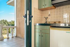a kitchen with green cabinets and a balcony at Anemona studio E in Kefallonia