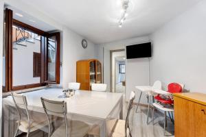 a dining room with a white table and chairs at Casa Vacanza Malva in Baveno