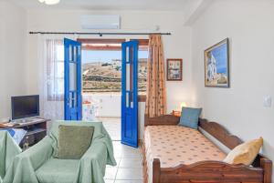 a living room with blue doors and a couch and chairs at Argyris comfy apartment in Kithnos