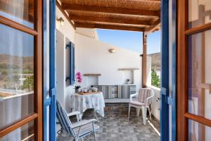 a room with a table and chairs on a balcony at Argyris comfy apartment in Kithnos