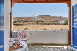 a room with a large window with a view of the desert at Argyris comfy apartment in Kithnos