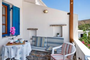 a patio with a table and chairs on a balcony at Argyris comfy apartment in Kithnos +14 photos