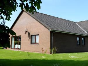 a brick house with a black roof at Ferienhaus Dunklau in Wesselburen