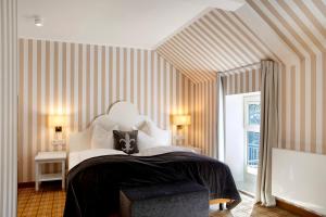 a bedroom with a large bed with striped walls at Kurhaus Masserberg in Masserberg