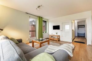 a living room with a couch and a table at Ferienhaus Dunklau in Wesselburen