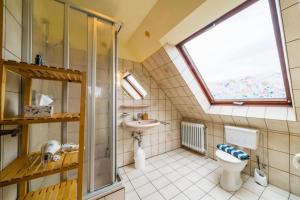 a bathroom with a toilet and a sink and a window at Olde Toornblick in Borkum
