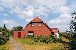 a red brick house on top of a field at Olde Toornblick in Borkum