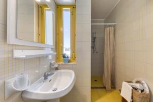 a white bathroom with a sink and a mirror at Bouganville in Leuca +13 photos