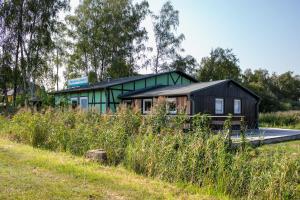 a black house in the middle of a field at Ferienhaus Im Teichland Linum in Fehrbellin