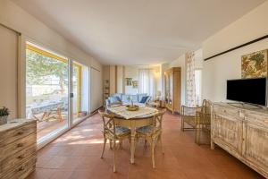 a living room with a table and chairs and a television at Bouganville in Leuca
