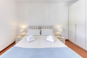 a bedroom with a large white bed with two lamps at Bouganville in Leuca