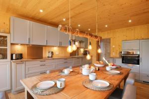 a kitchen with a wooden table with plates on it at Ferienhaus Im Teichland Linum in Fehrbellin