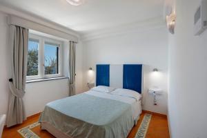 a bedroom with a bed and two windows at Suite Aurora in dependance in Conca dei Marini