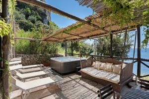 a patio with a couch and a hot tub at Suite Aurora in dependance in Conca dei Marini